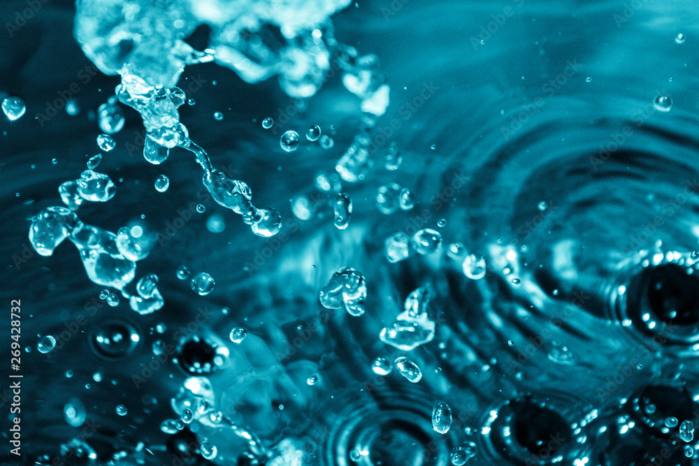 splashes and flying drops of water on a dark background, bokeh defocused 