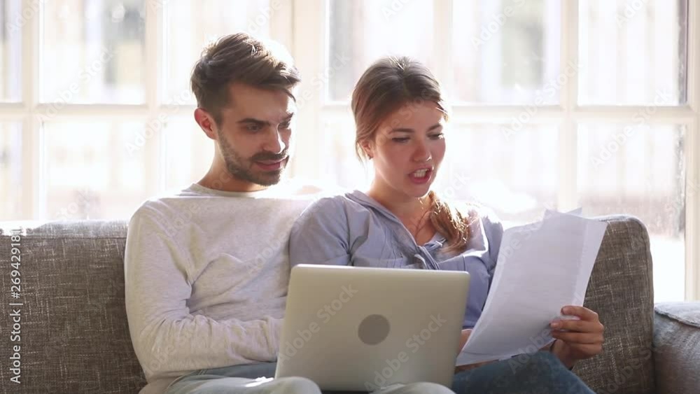 Happy couple checking easy service to pay domestic bills online Happy couple checking easy service to pay domestic bills online