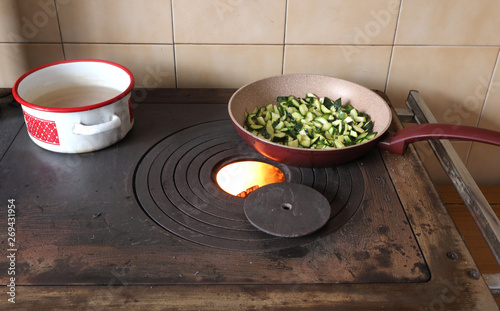 zucchini are cooked over a stove in a mountain hut