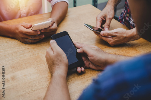 group of friends or young people hands using smart phone playing social networking sitting on table at home office, digital technology, WiFi internet, network connection and relationship concept