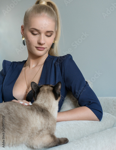 blond girl in bra and dark blue jacket. Fashion woman in ligth room.