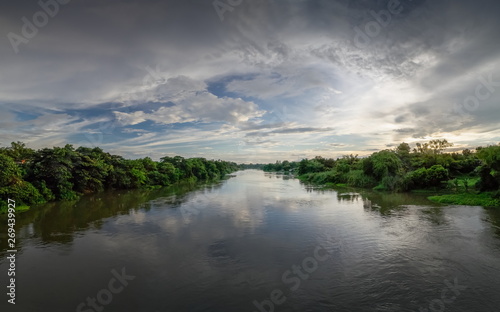 Fototapeta Naklejka Na Ścianę i Meble -  Panorama river view evening of Mae Klong river with soft rain and cloudy sky background, Ban Pong District, Ratchaburi, Thailand.