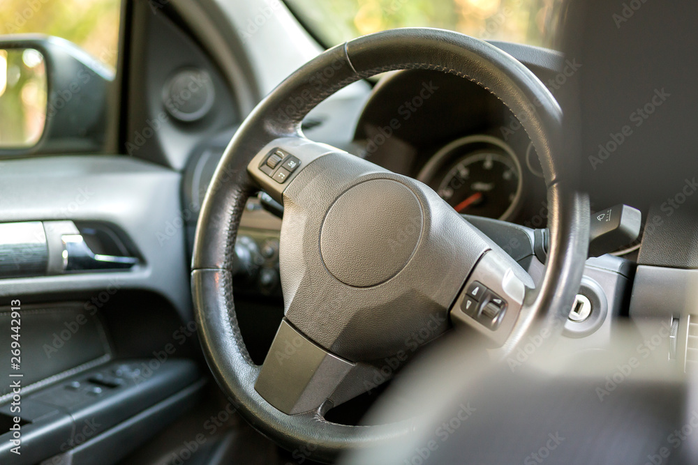 Modern expensive car black luxurious interior. Steering wheel, dashboard, windshield and mirror. Transportation, design, modern technology concept. Modern expensive car black luxurious interior. Steering wheel, dashboard, windshield and mirror. Transportation, design, modern technology concept.