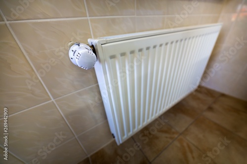 Wallpaper Mural Close-up of white heating radiator with thermostat valve ion tiled walls and floor background. Comfortable warm home interior, climate control, money saving concept. Torontodigital.ca