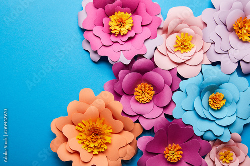 Fototapeta Naklejka Na Ścianę i Meble -  top view of colorful paper cut flowers on blue background