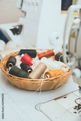 Sewing concept. Lot of thread coils next to the sewing machine.
