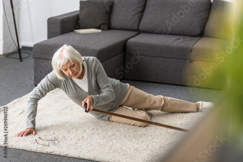 suffering senior woman with heart attack on carpet © LIGHTFIELD STUDIOS