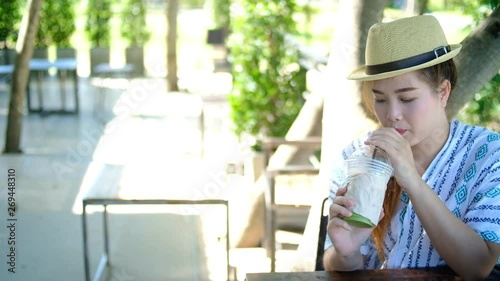 Asian woman drinking iced green tea in the coffee shop