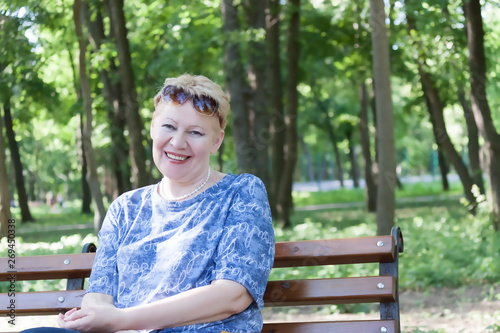 Portrait of a mature woman sitting in a park on a bench