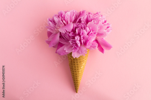 Canvas Print Ice cream cone with pink peonies  in the center of the pink background
