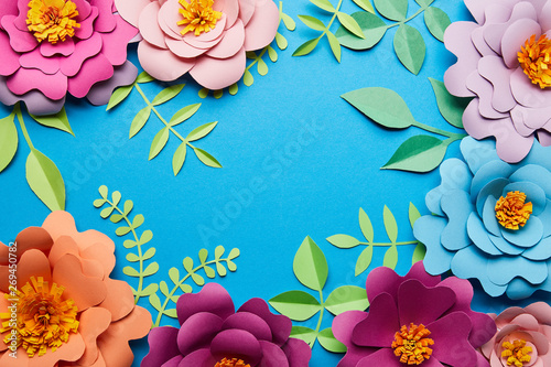Fototapeta Naklejka Na Ścianę i Meble -  top view of multicolored paper cut flowers with leaves on blue background with copy space