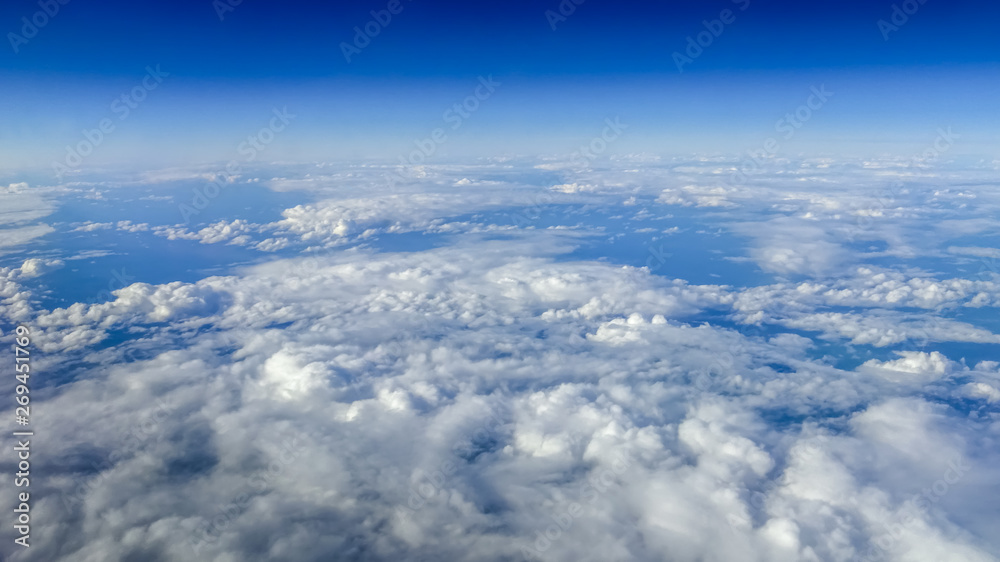 Naklejka premium The beautiful cloudscape with clear blue sky. A view from airplane window.