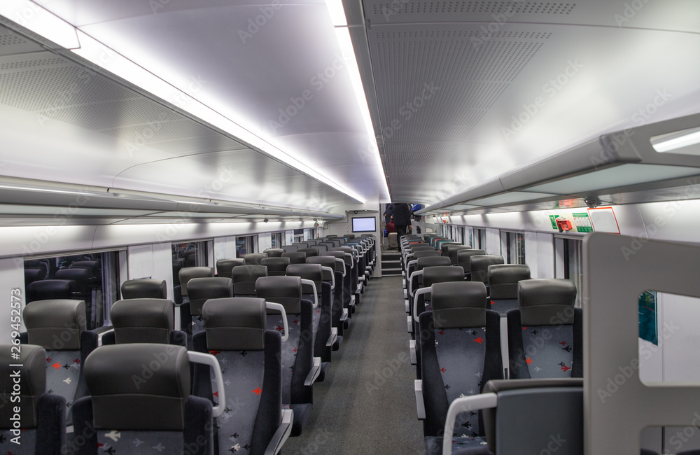 Interior high-speed passenger train with empty blue seats