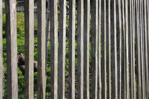 Old gray weathered garden fence made of wooden slats - vertical texture for background