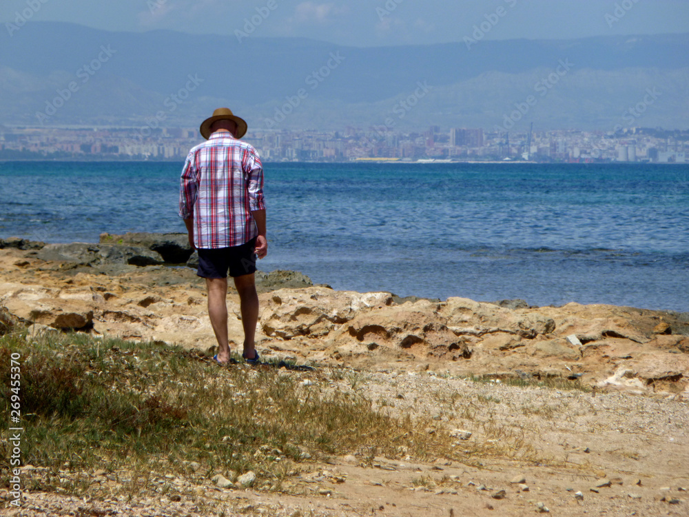 man walking by the seashore in summer