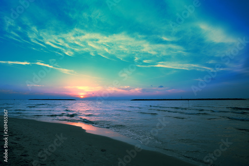 Early morning, sunrise over sea. Blue pink beautiful sunrise. Twilight time on the beach.