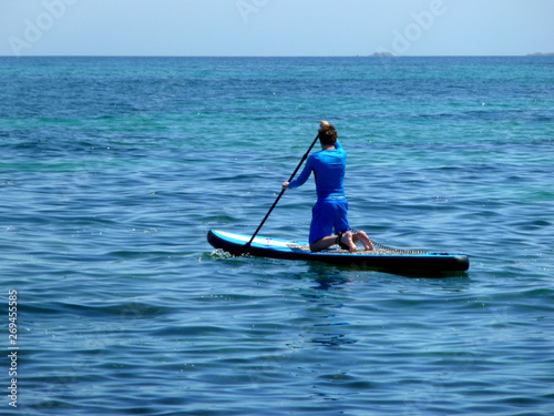 young man practicing paddle on the beach with calm sea © Julio
