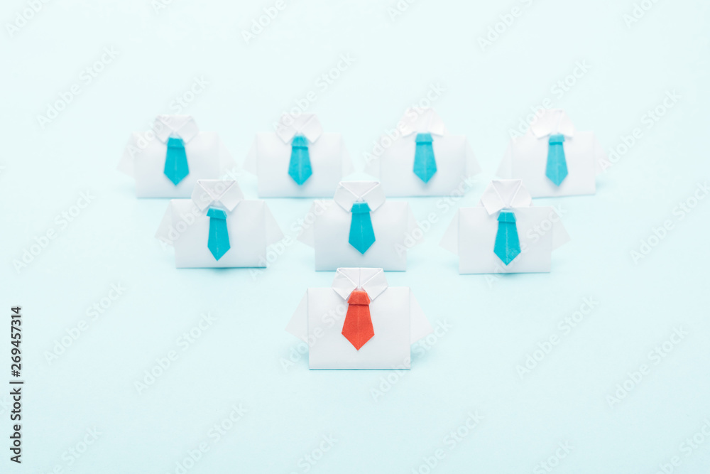 origami white shirts with blue ties with one red on blue background, leadership concept origami white shirts with blue ties with one red on blue background, leadership concept