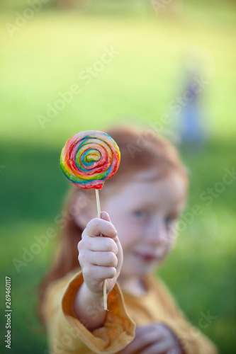 Girl holding a colorful lollipop photo