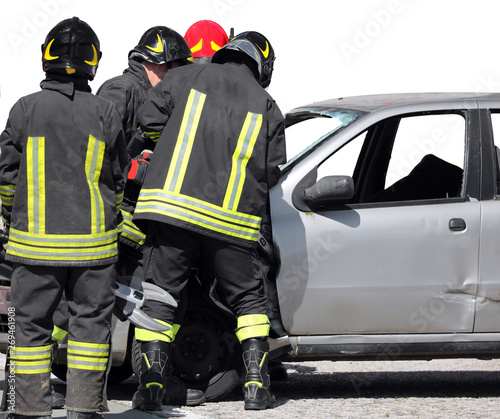 team of firefighters and a broken car