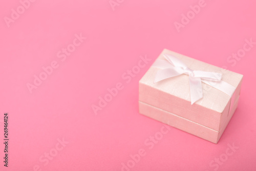 Gift or present box and stars confetti on pink table top view. Flat lay composition for birthday, mother day or wedding.