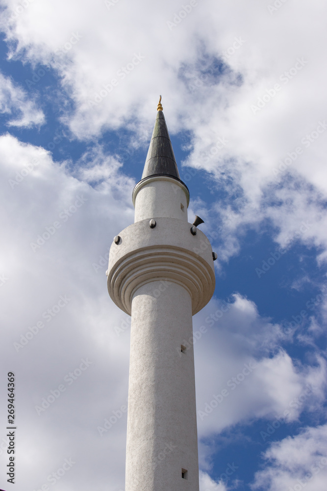 Minaret of a Muslim mosque on the background of the cloudy sky. one minaret staring to heaven, a religious Muslim shrine Minaret of a Muslim mosque on the background of the cloudy sky. one minaret staring to heaven, a religious Muslim shrine