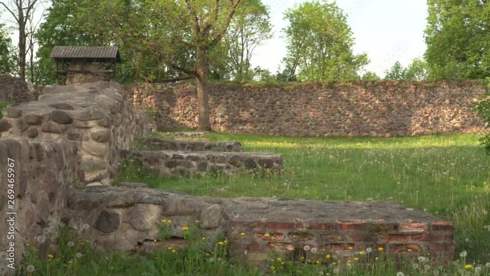 Foundations of old castle stone wall. 13th century Livonia Order castle ruins territory in the old town Dobele, Latvia. Summer of 2019. Foundations of old castle stone wall. 13th century Livonia Order castle ruins territory in the old town Dobele, Latvia. Summer of 2019.
