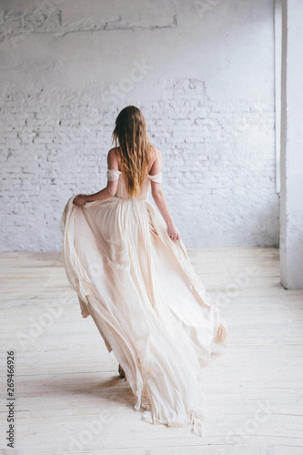 Fashion model in a beautiful beige flowing dress.