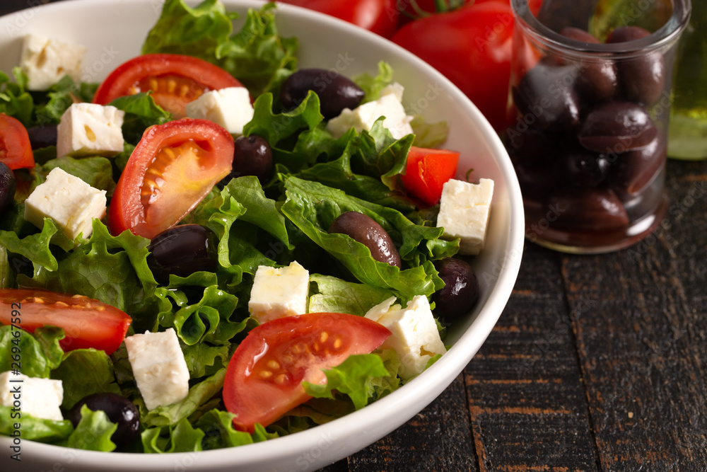 Greek Salad with Olives Tomatos and Feta Cheese on a Rustic Wood Table Greek Salad with Olives Tomatos and Feta Cheese on a Rustic Wood Table