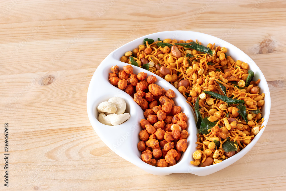 Assortment spicy crunchy indian mix Nimco or Namkeen and spicy coated peanut white bowl wooden background. Assortment spicy crunchy indian mix Nimco or Namkeen and spicy coated peanut white bowl wooden background.