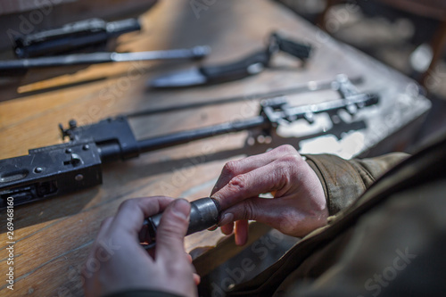 male person soldier cleans the weapon, disassemble, make maintenance of service weapon