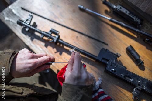 male person soldier cleans the weapon, disassemble, make maintenance of service weapon