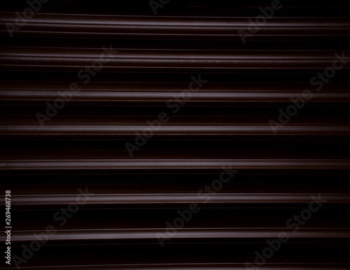 Dark wood background with dramatic light. Detailed shot of wooden blinds texture.