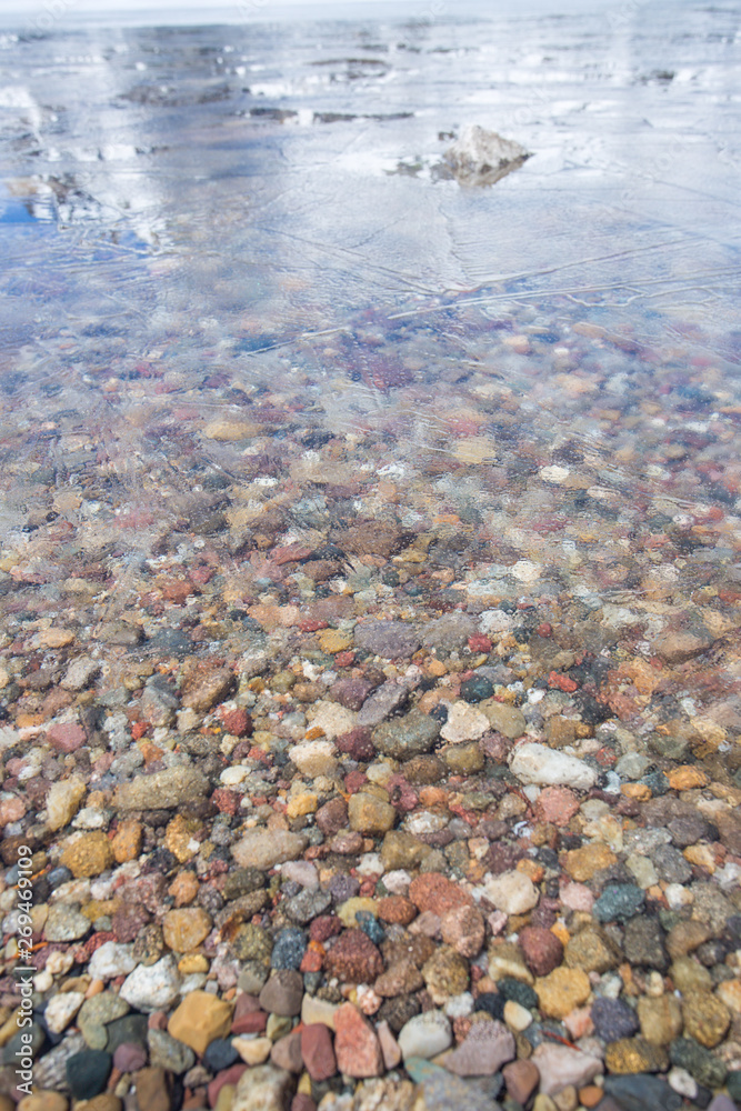 Lake rocks below a thin layer of ice in Jenny Lake, Grand Teton National Park, Wyoming. Taken during the afternoon in mid-May. Lake rocks below a thin layer of ice in Jenny Lake, Grand Teton National Park, Wyoming. Taken during the afternoon in mid-May.