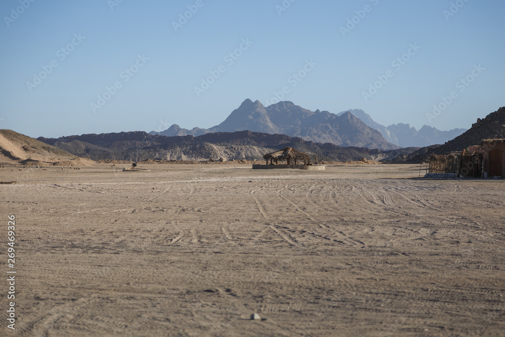 Sunny noon in bedouin village with mountain view of desert near Hurghada, Egypt. Space for text Sunny noon in bedouin village with mountain view of desert near Hurghada, Egypt. Space for text