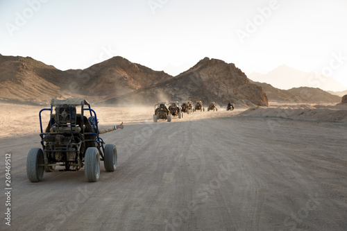 Fotografie Extreme buggy races at sunset near the mountains and a Bedouin village in the desert near Hurghada