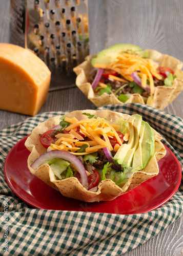 Taco Salad in a Crunch Corn Tortilla Bowl Isolated on Wooden Table