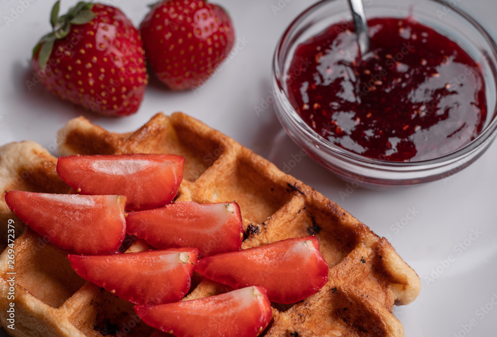 Homemade waffles with berry and nuts on black table background. Sweet dessert. Delicious food