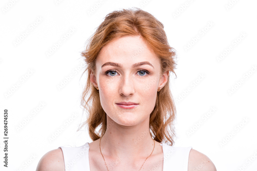 Portrait of a beautiful young woman of European, Caucasian nationality with long red hair and freckles on her face posing on a white background in the studio. Close-up student girl in a white blouse Portrait of a beautiful young woman of European, Caucasian nationality with long red hair and freckles on her face posing on a white background in the studio. Close-up student girl in a white blouse
