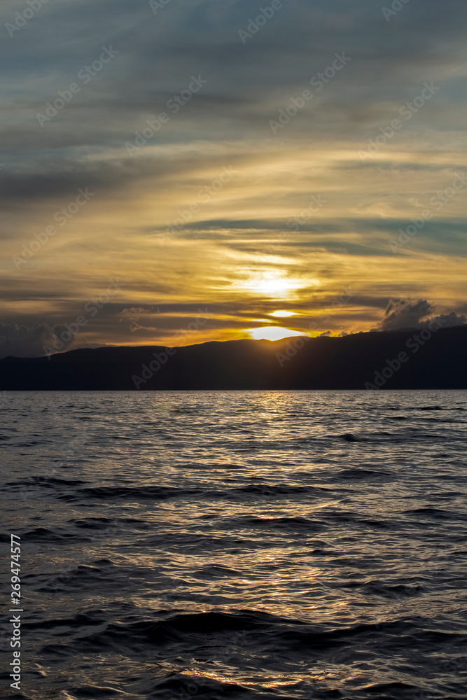 Fototapeta premium A scenic sunset over the dark-silver waters