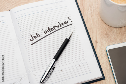 Wallpaper Mural notebook with pen and job interview lettering on wooden table near smartphone and coffee cup Torontodigital.ca