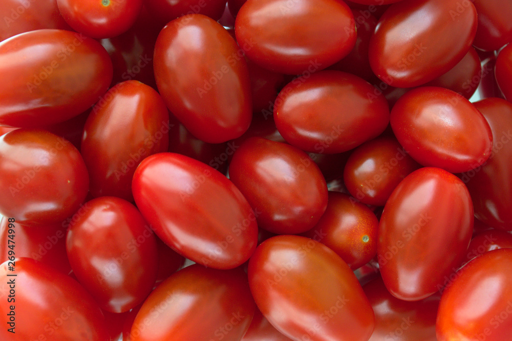 Shiny fresh red plum cherry tomatoes on the market. Close up. Macro. Shiny fresh red plum cherry tomatoes on the market. Close up. Macro.