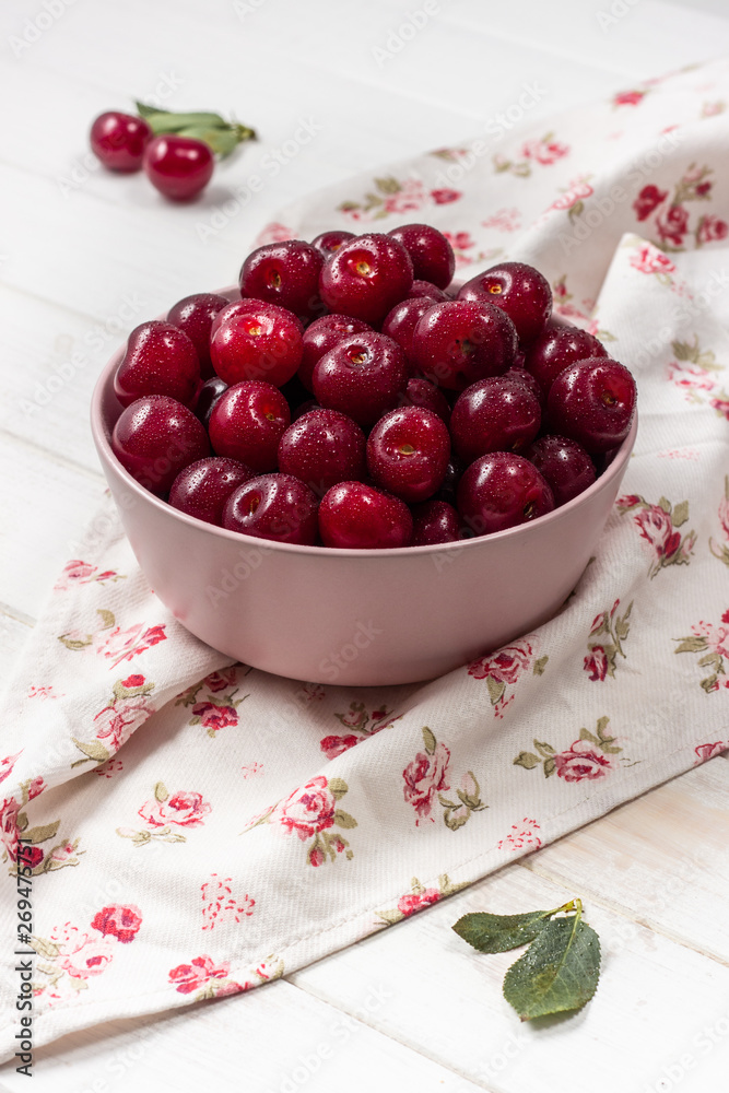 Cherry fresh in a pink plate on a light background Cherry fresh in a pink plate on a light background