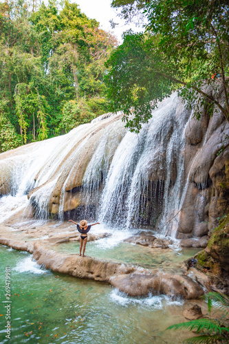 Woman swimming in the natural pools of the emerald waterfalls at Roberto Barrios in Chiapas, Mexico