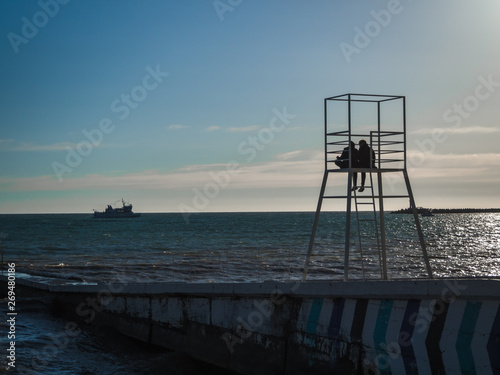Silhouette of a loving couple on a lifeguard tower