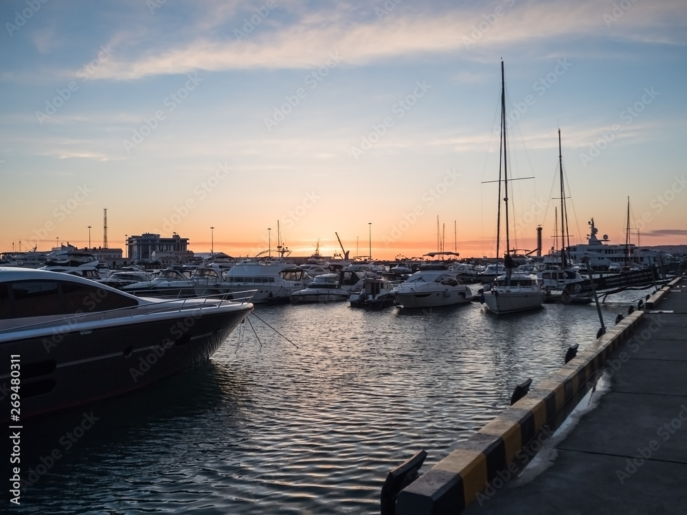 Sea pier with yachts in the evening at sunset in Sochi