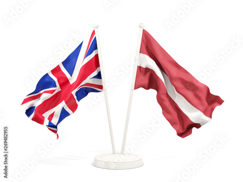 Two waving flags of UK and latvia isolated on white