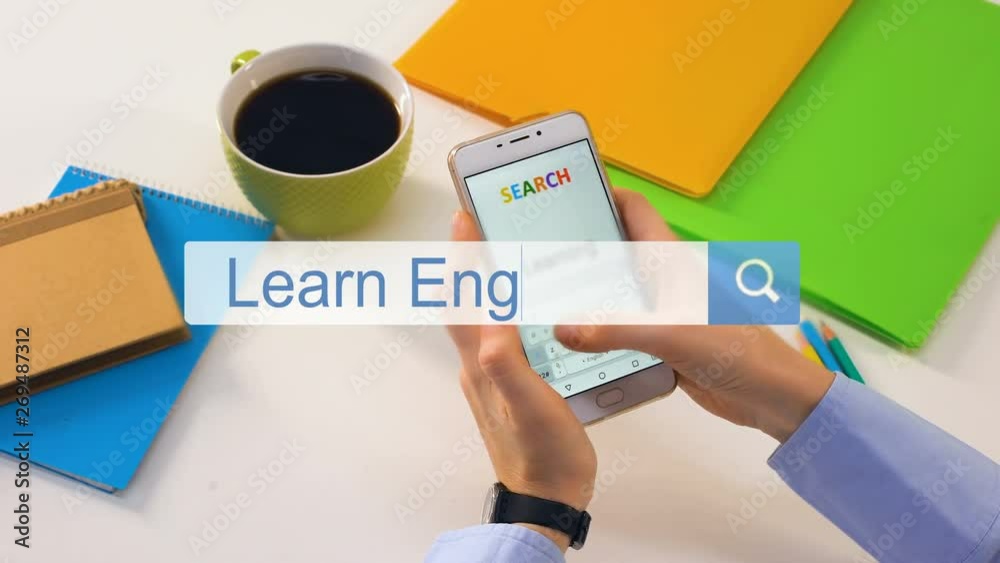Person inserting learn English phrase on smartphone search bar, education