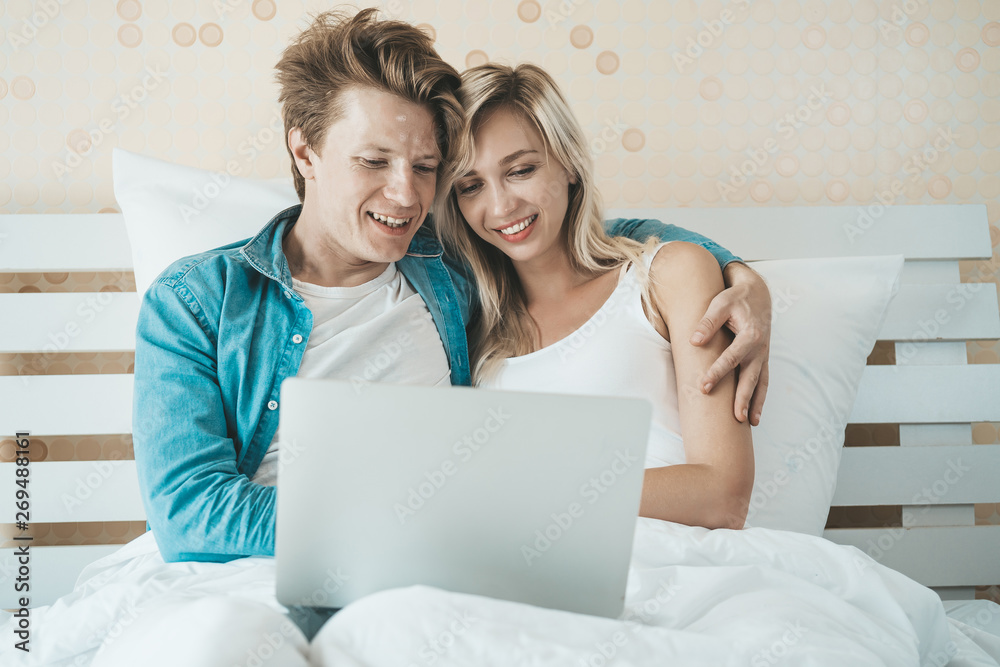 Happy couple Using laptop computer on the bed Happy couple Using laptop computer on the bed