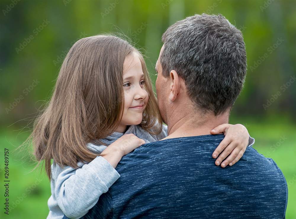 Girl hugging her father. Happy loving family. Dad and his daughter playing. Cute baby and daddy. Concept of Father day. Family holiday and togetherness. Green background Girl hugging her father. Happy loving family. Dad and his daughter playing. Cute baby and daddy. Concept of Father day. Family holiday and togetherness. Green background